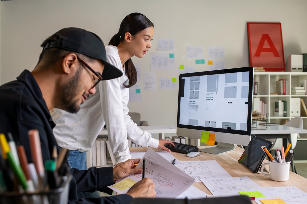UX UI designers discussing and brainstorming on wireframes for a website